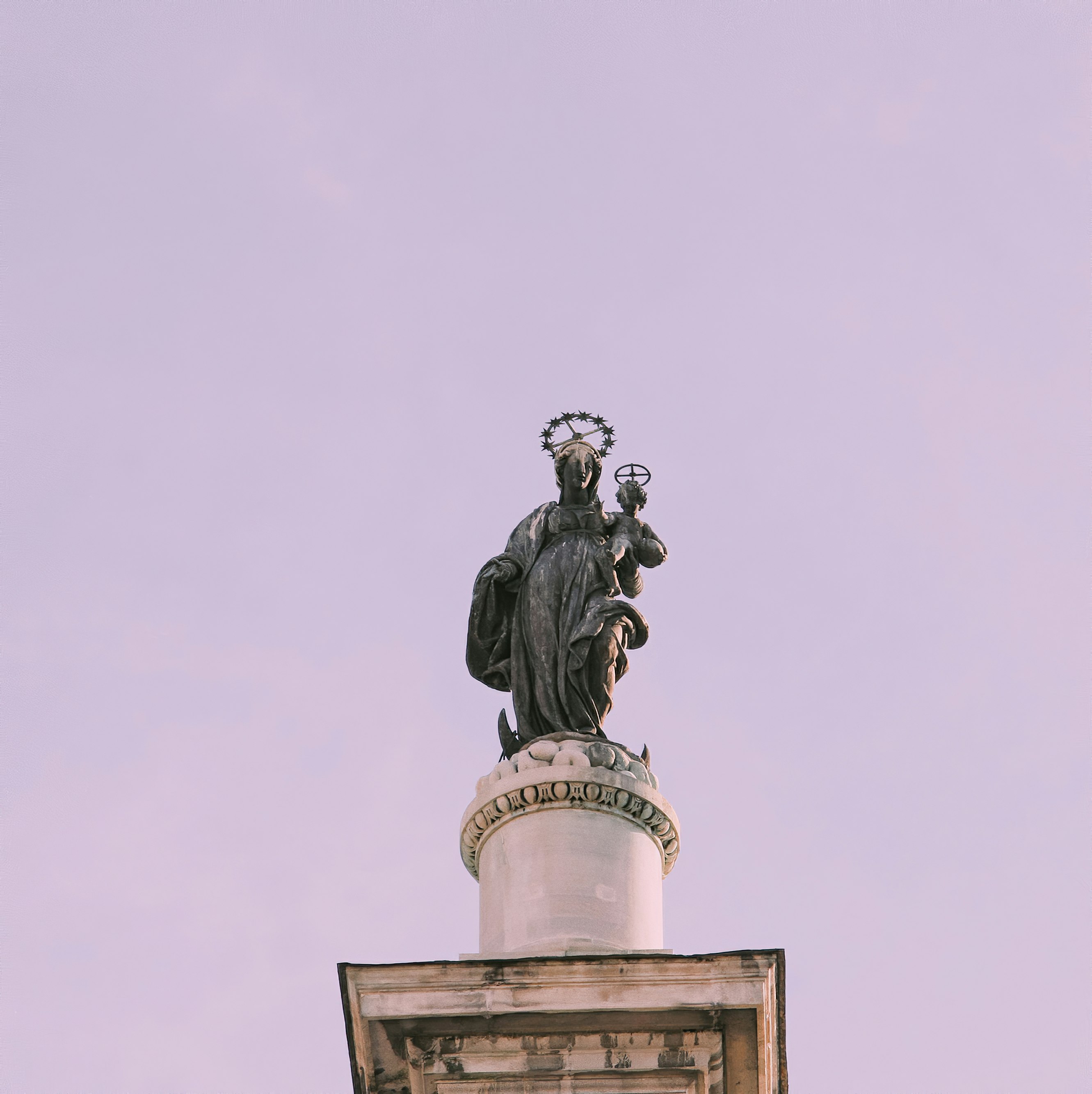 black statue of man on top of building
